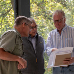 Men on porch Tavernier Place Acton 092325 Dunn 1